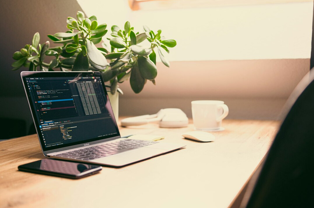 person coding on laptop at desk